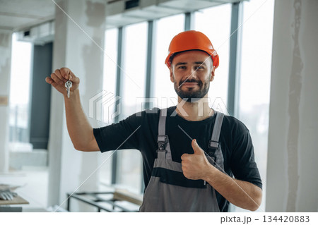 Buy it. Happy construction worker is holding keys for new home Buy it. Happy construction worker is holding keys for new home 134420883