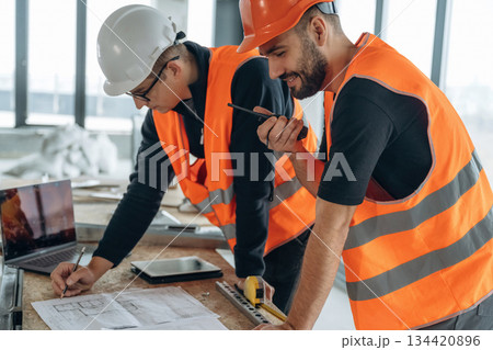 In the unfinished room together. Two construction workers In the unfinished room together. Two construction workers 134420896