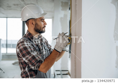 Focused on the work. A man is renovating an unfinished room Focused on the work. A man is renovating an unfinished room 134420971