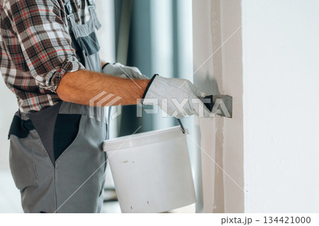Close up view of worker that is renovating unfinished room Close up view of worker that is renovating unfinished room 134421000