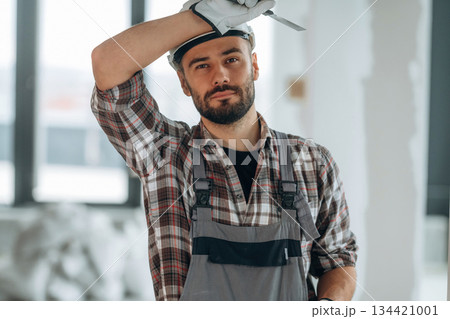 Taking a break. A man is renovating an unfinished room Taking a break. A man is renovating an unfinished room 134421001