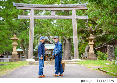 鳥居前のデニム着こなしシニア夫婦 134421179
