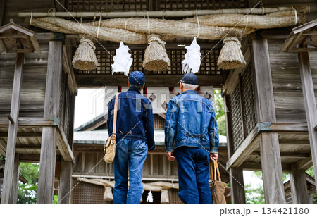 神社を訪れるデニム姿のシニア男性2人 134421180