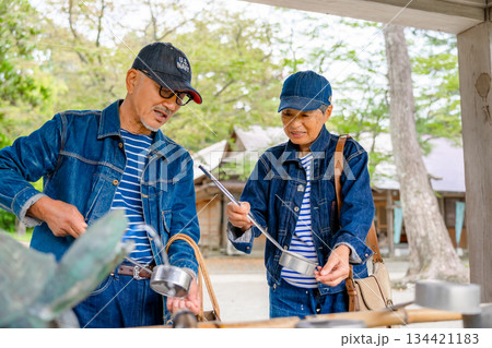 神社で手水を使う老夫婦 134421183