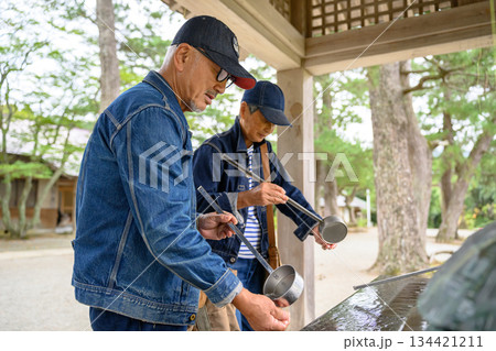 神社で手水を行うシニア男性二人 134421211