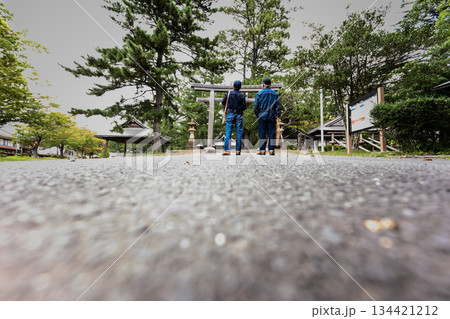 神社参道に立つデニムのシニア夫婦 134421212