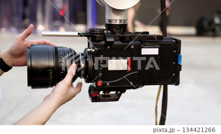 Behind the scenes of movie shooting or video production and film crew team with camera equipment at outdoor location. Video camera with professional robotic arm. BTS of Filming camera setup at outdoor 134421266