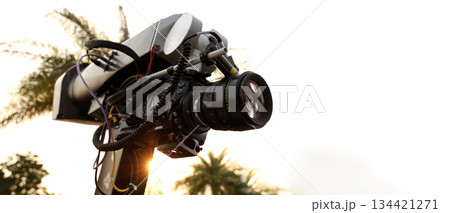 Behind the scenes of movie shooting or video production and film crew team with camera equipment at outdoor location. Video camera with professional robotic arm. BTS of Filming camera setup at outdoor Behind the scenes of movie shooting or video production and film crew team with camera equipment at outdoor location. Video camera with professional robotic arm. BTS of Filming camera setup at outdoor 134421271