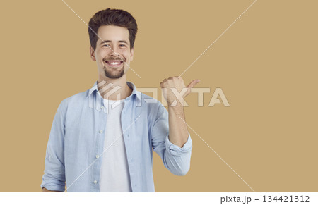 Happy man pointing finger at copy space for promotional product presenting sale discount promo offer Happy man pointing finger at copy space for promotional product presenting sale discount promo offer 134421312