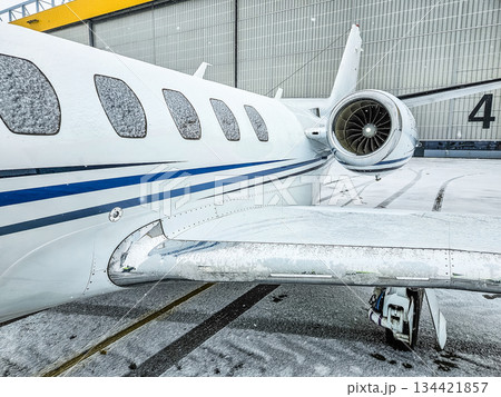 Snow-Covered Business Jet Engine on Winter Airport Apron 134421857