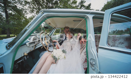 Vintage car interior framing wedding couple, passionately kissing, celebrating matrimonial love with intimate, nostalgic elegance Vintage car interior framing wedding couple, passionately kissing, celebrating matrimonial love with intimate, nostalgic elegance 134422412