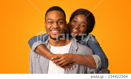 Closeup Shot Of Happy Romantic Young African American Couple Embracing And Smiling At Camera, Loving Millennial Black Man And Woman Hugging While Posing Together Over Yellow Background, Free Space Closeup Shot Of Happy Romantic Young African American Couple Embracing And Smiling At Camera, Loving Millennial Black Man And Woman Hugging While Posing Together Over Yellow Background, Free Space 134422504