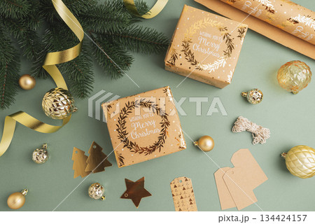 Christmas Gift Wrapping Flatlay with Ornaments and Tags on Green Background 134424157
