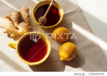Flat Lay with Lemon Tea, Ginger and Honey on Light Table under Sun Light 134424193