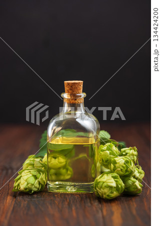 Hop Extract in Glass Bottle with Fresh Hops on Wooden Surface Hop Extract in Glass Bottle with Fresh Hops on Wooden Surface 134424200