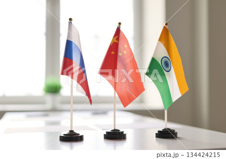Trilateral mini table flags for diplomacy on meeting desk, symbols of cooperation 134424215