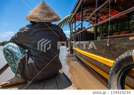 Local Woman Paddling Traditional Canoe by a Cruise Boat Mekong Delta, Vietnam 134424234
