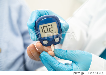 Doctor check diabetes from finger blood sugar level with finger lancet. Doctor check diabetes from finger blood sugar level with finger lancet. 134424314