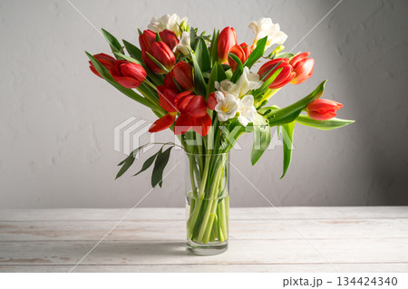 Spring floral background. Red tulips and Fresia white flower bouquet. Spring floral background. Red tulips and Fresia white flower bouquet. 134424340