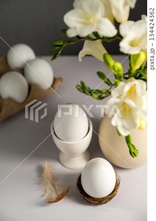 Spring, Easter background. White freesias flowers in a vase with white eggs. Spring, Easter background. White freesias flowers in a vase with white eggs. 134424362