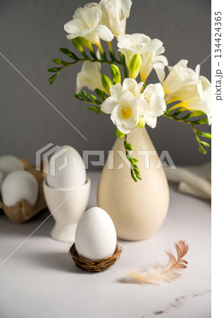 Spring, Easter background. White freesias flowers in a vase with white eggs. 134424365