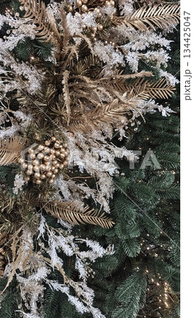 Golden and white Christmas decorations on a green pine tree create a luxurious festive arrangement. Symbol of celebration, holiday spirit, elegance and seasonal beauty Golden and white Christmas decorations on a green pine tree create a luxurious festive arrangement. Symbol of celebration, holiday spirit, elegance and seasonal beauty 134425047