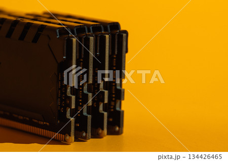 Macro view of stacked RAM module ends on yellow background Macro view of stacked RAM module ends on yellow background 134426465