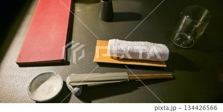 Japanese dining setup with chopsticks, towel, and empty glass on table Japanese dining setup with chopsticks, towel, and empty glass on table 134426566