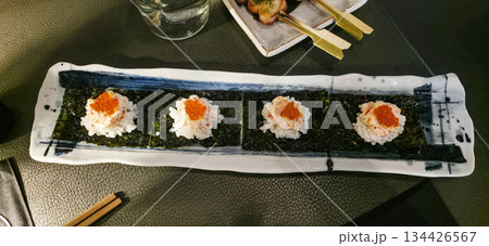 Sushi rolls on a decorative plate with vibrant toppings and elegant presentation 134426567