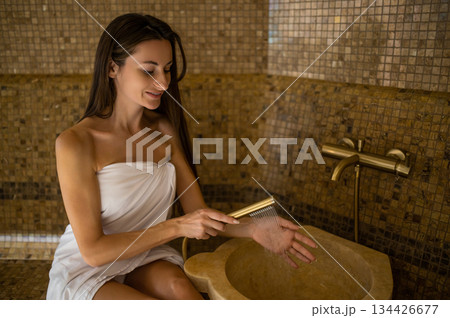 Long-haired smiling relaxed woman enjoying hammam procedures Long-haired smiling relaxed woman enjoying hammam procedures 134426677