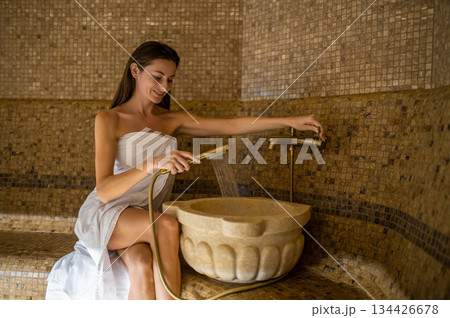 Long-haired smiling relaxed woman enjoying hammam procedures Long-haired smiling relaxed woman enjoying hammam procedures 134426678