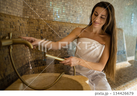 Long-haired smiling relaxed woman enjoying hammam procedures Long-haired smiling relaxed woman enjoying hammam procedures 134426679