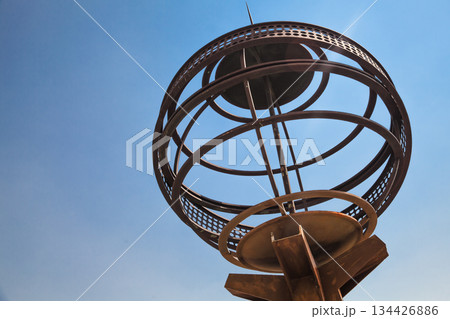 A weathered metal globe shaped object featuring interconnected rings 134426886
