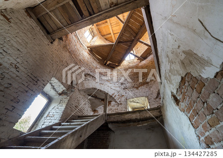 Large spacious forsaken empty basement room of ancient building or palace with cracked plastered brick walls, small windows, dirty floor and wooden staircase ladder. Large spacious forsaken empty basement room of ancient building or palace with cracked plastered brick walls, small windows, dirty floor and wooden staircase ladder. 134427285
