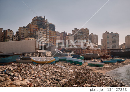 Small Fishing Boats on Rocky Urban Shoreline Small Fishing Boats on Rocky Urban Shoreline 134427288