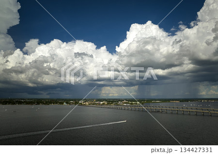 Heavy thunderstorm approaching traffic bridge connecting Punta Gorda and Port Charlotte over Peace River. Bad weather conditions for driving during rainy season in Florida 134427331