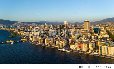 Aerial view of Izmir city skyline along the coastline with urban buildings, waterfront, sea and distant mountains. Turkey. Aerial view of Izmir city skyline along the coastline with urban buildings, waterfront, sea and distant mountains. Turkey. 134427353