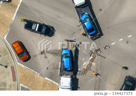 First responders helping on car accident site. Tow truck loading crashed car. Emergency services responding to vehicle crash on American street 134427373