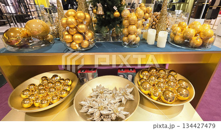 Berlin, Germany - September 19, 2025: Golden Christmas ornaments displayed on festive table with decorations 134427479