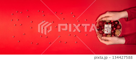 Christmas Basket with Red Baubles and Gift on Red Background Christmas Basket with Red Baubles and Gift on Red Background 134427588