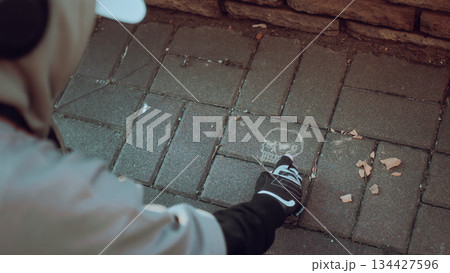 cropped view of man painting colorful graffiti on wall 134427596