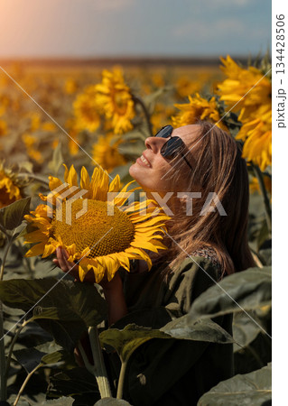 A girl in a pink skirt and a white T-shirt walks through a field of blooming yellow sunflowers. A woman dances, rejoices, smiles, enjoys life, warmth, summer, the sun. High quality FullHD footage A girl in a pink skirt and a white T-shirt walks through a field of blooming yellow sunflowers. A woman dances, rejoices, smiles, enjoys life, warmth, summer, the sun. High quality FullHD footage 134428506