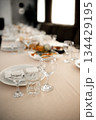 empty wine glasses on banquet served table in open air in rays of setting sun 134429195