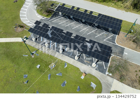 Destroyed by hurricane wind solar panels installed over parking lot canopy shade for parked cars for effective generation of clean energy. Damage from severe weather to Florida infrastructure 134429752