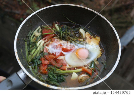 Fried eggs with spinach and pumpkin,shalots  in a frying pan- healthy eating 134429763