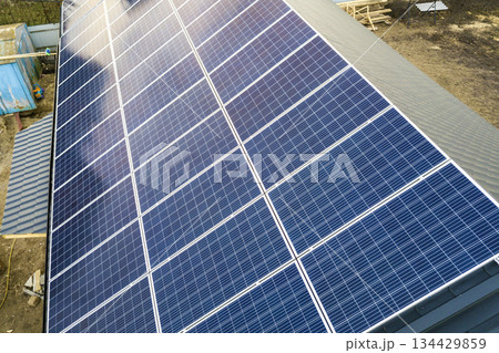 Close-up surface of blue shiny solar photo voltaic panels system on building roof. Renewable ecological green energy production concept. 134429859