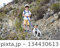 Child learning through nature while hiking with pet dog in the mountains 134430613