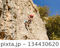Child rock climbing training with safety equipment on natural rock wall. Snappelling (Rappelling) in Israel. 134430620