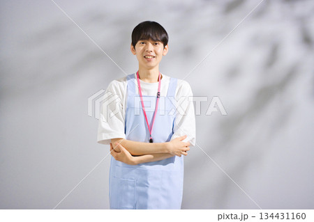 エプロンをした20代男性保育士 134431160