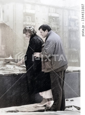 A vintage portrait of a bride and groom laying flowers at a monument to soldiers who died in World War II after their wedding ceremony. Photo from 1993. 134431807